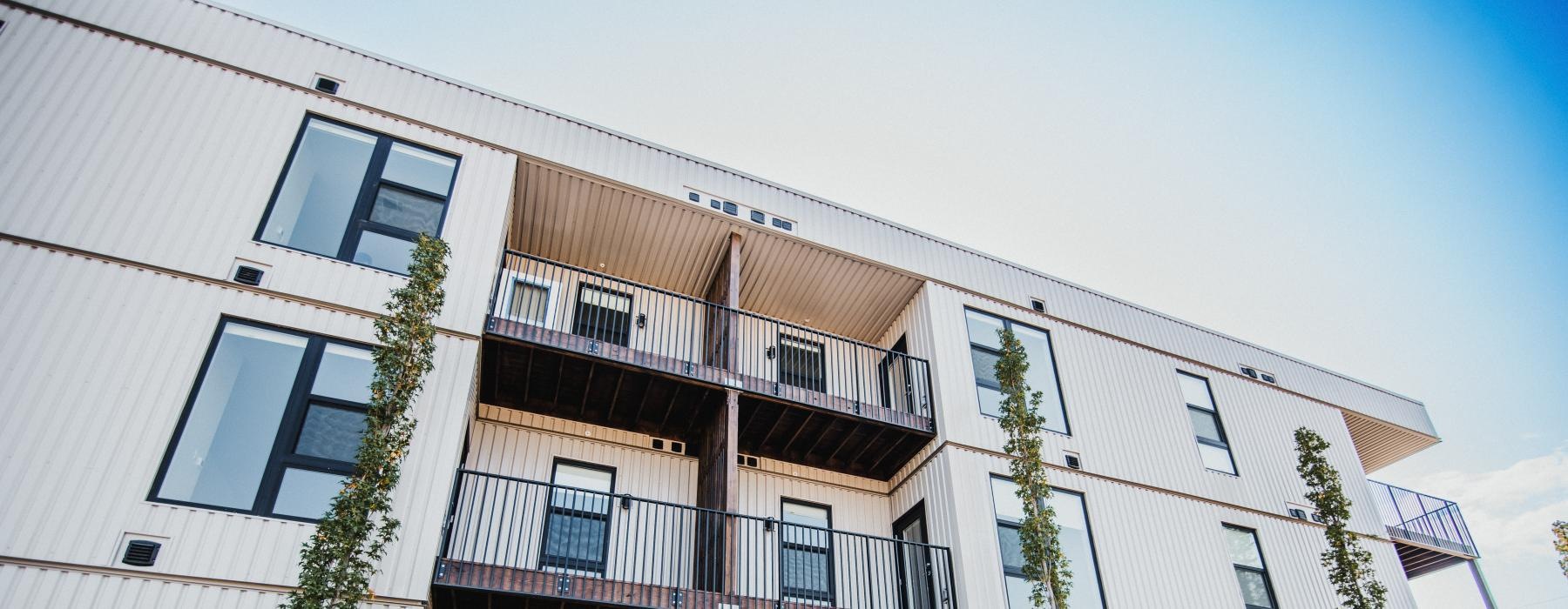 a building with balconies and trees in front of it